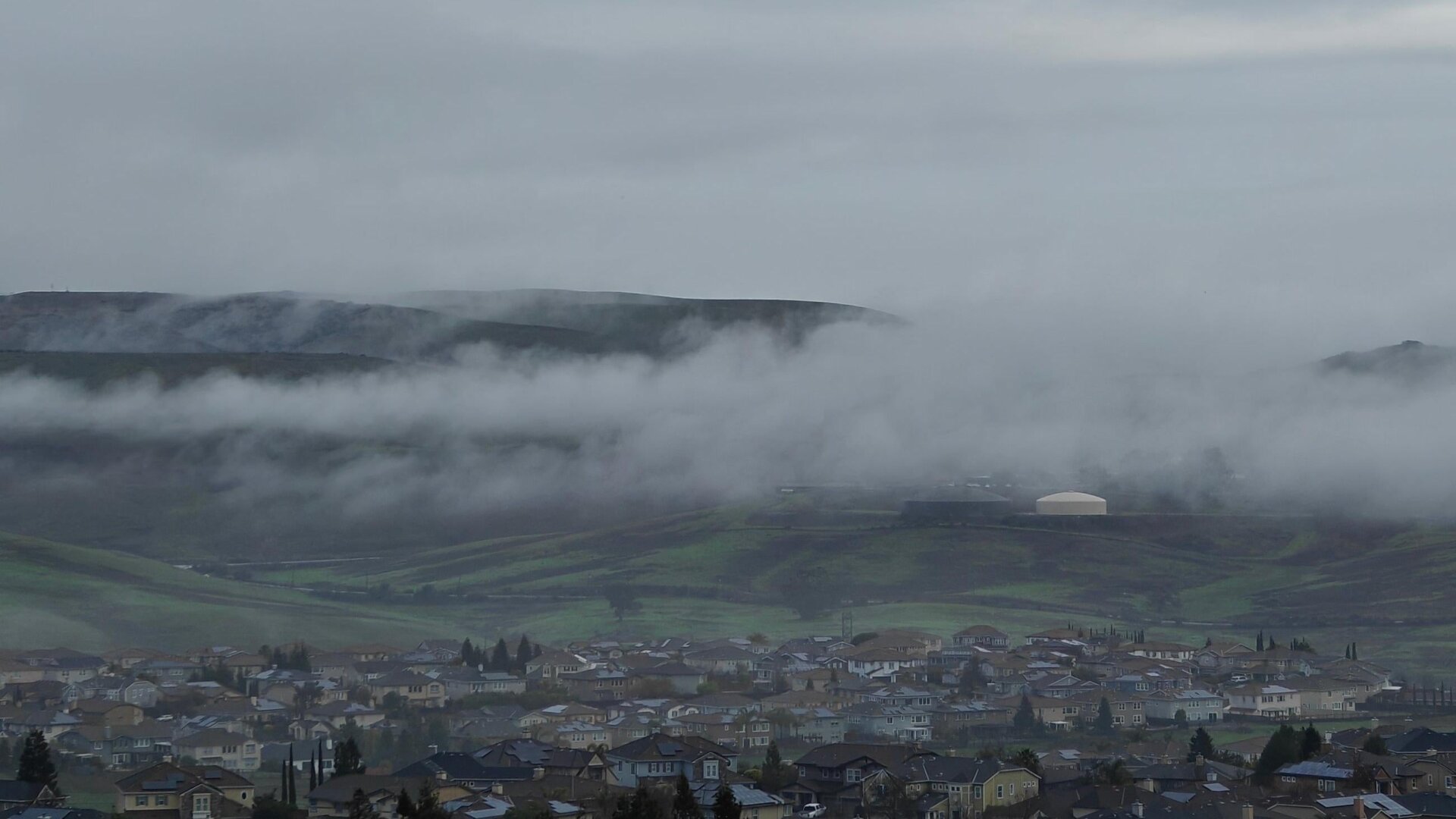 Ein frühmorgendliches Foto von  Nebel, der über die Hügel zieht, aufgenommen mit dem OnePlus 12 auf einem Stativ. 