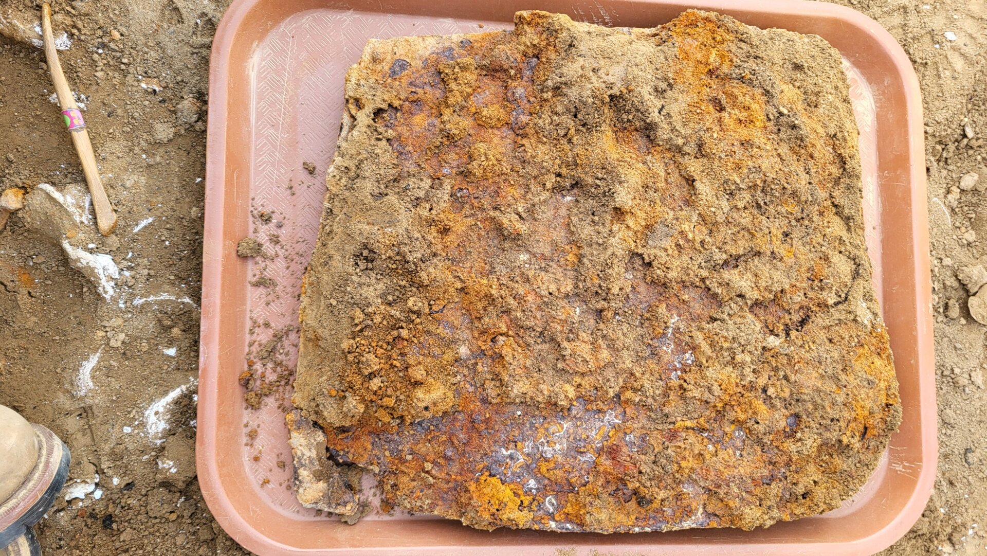 Der mit Erde verkrustete Beutel kurz nach der Ausgrabung.