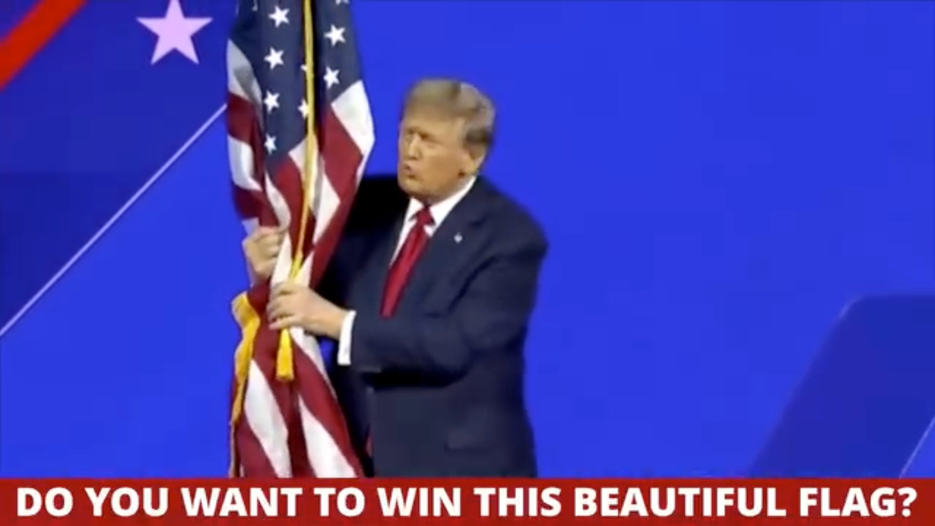 Screenshot einer Videoanzeige, die derzeit auf Facebook läuft und zeigt, wie Trump eine amerikanische Flagge ergreift und Kampagnenmitwirkenden die Chance bietet, sie zu gewinnen. 