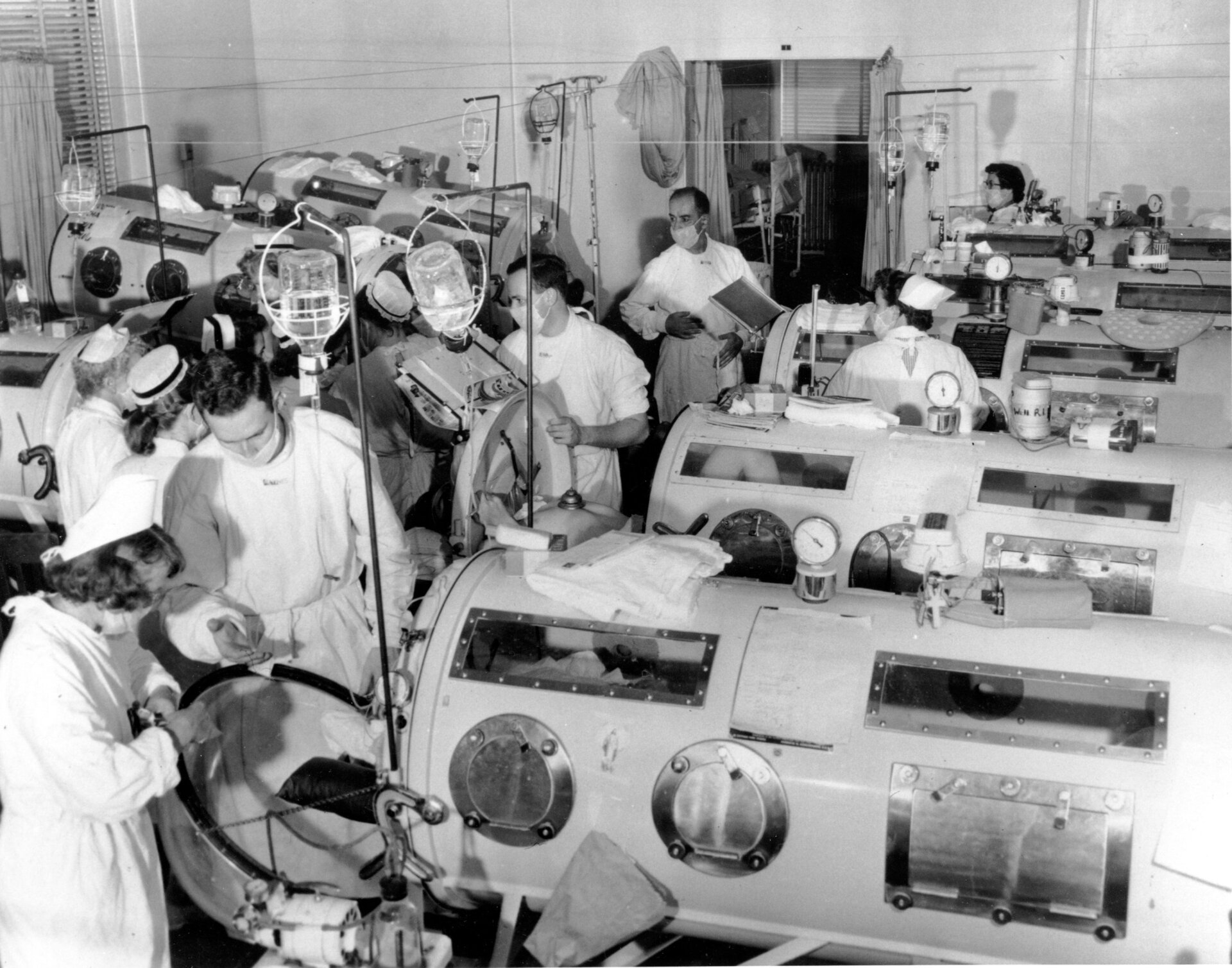Dies ist eine Szene in der Polio-Notaufnahme des Haynes Memorial Hospital in Boston, MA, am 16. August 1955. Die Stadt Die Polio-Epidemie erreichte mit 480 Fällen einen Höchststand. Die kritischen Patienten stehen in eisernen Lungenbeatmungsgeräten dicht aneinandergereiht, so dass eine Ein Team aus Ärzten und Pflegekräften kann bei Bedarf eine schnelle Notfallbehandlung durchführen 