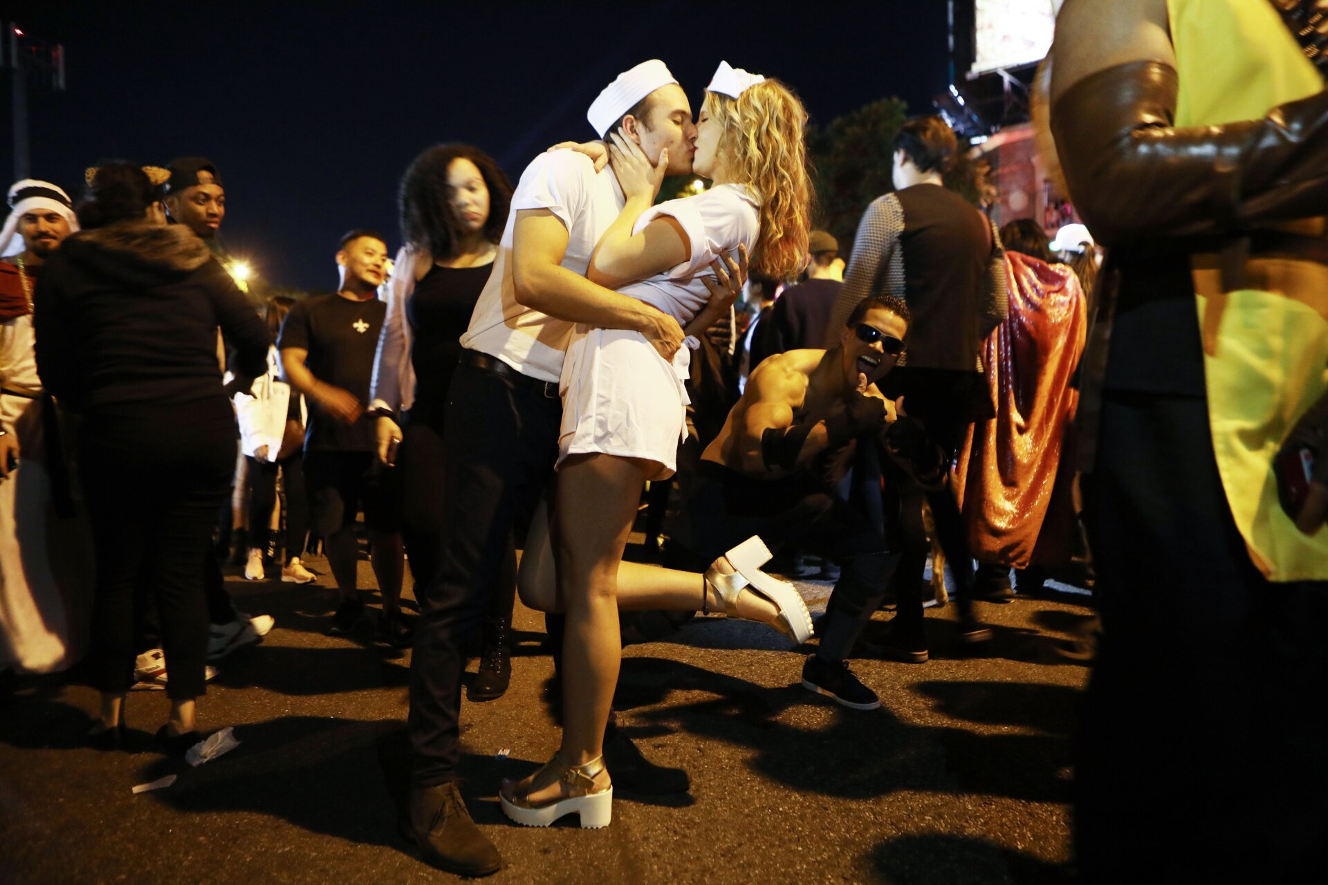 Nachtschwärmer küssen sich und geben sich als Motive im berühmten Kussfoto des Times Square von Alfred Eisenstaedt auf der alljährlichen Straßenparty „Hollywood Carnaval“ aus am 31.Oktober 2018, im West-Hollywood, Kalifornien.