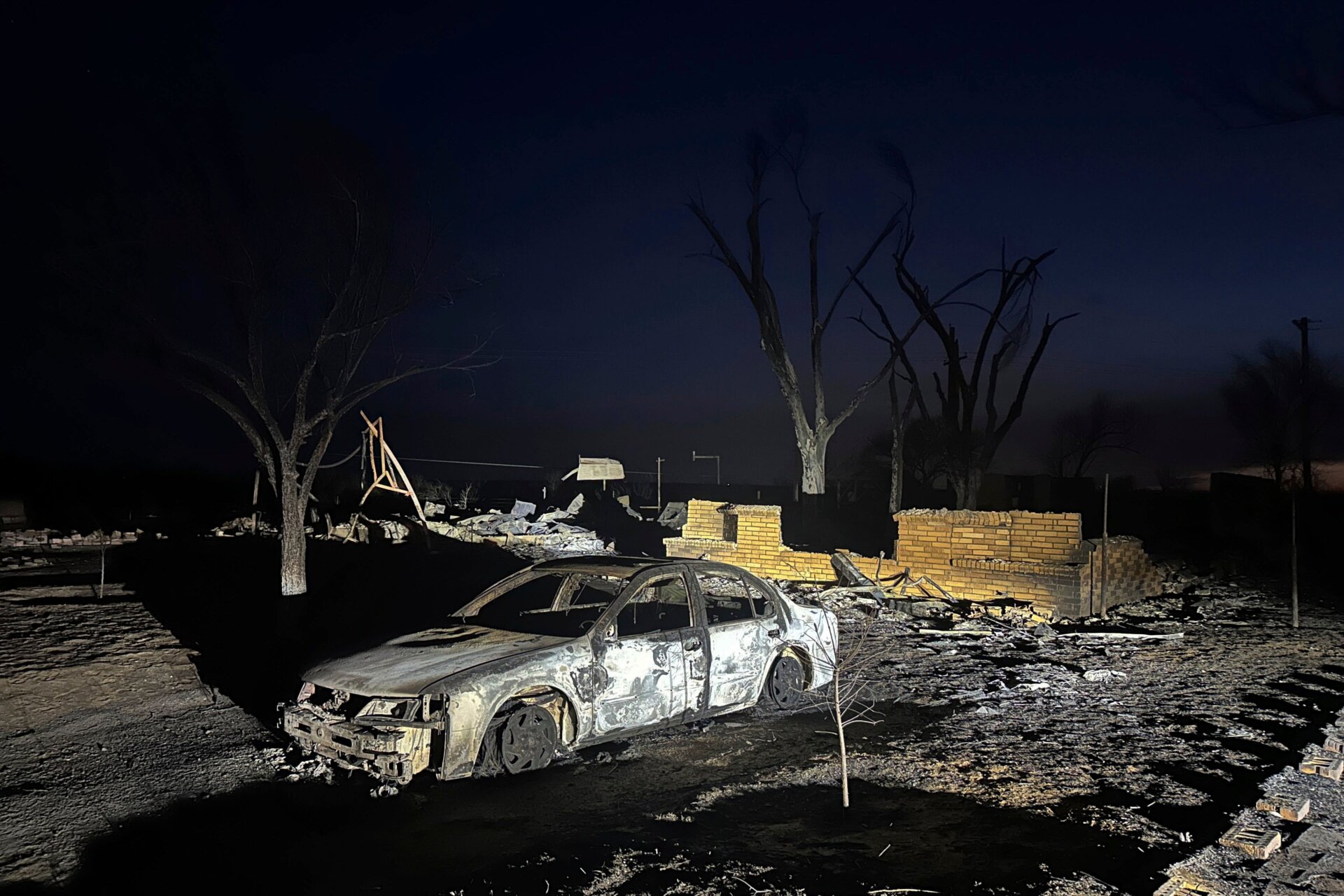 Ein verkohltes Fahrzeug steht in der Nähe der Ruinen eines Hauses, nachdem das Grundstück durch das Feuer von Smokehouse Creek niedergebrannt war, Mittwoch, 28. Februar.  2024, in  Fritch, Texas.