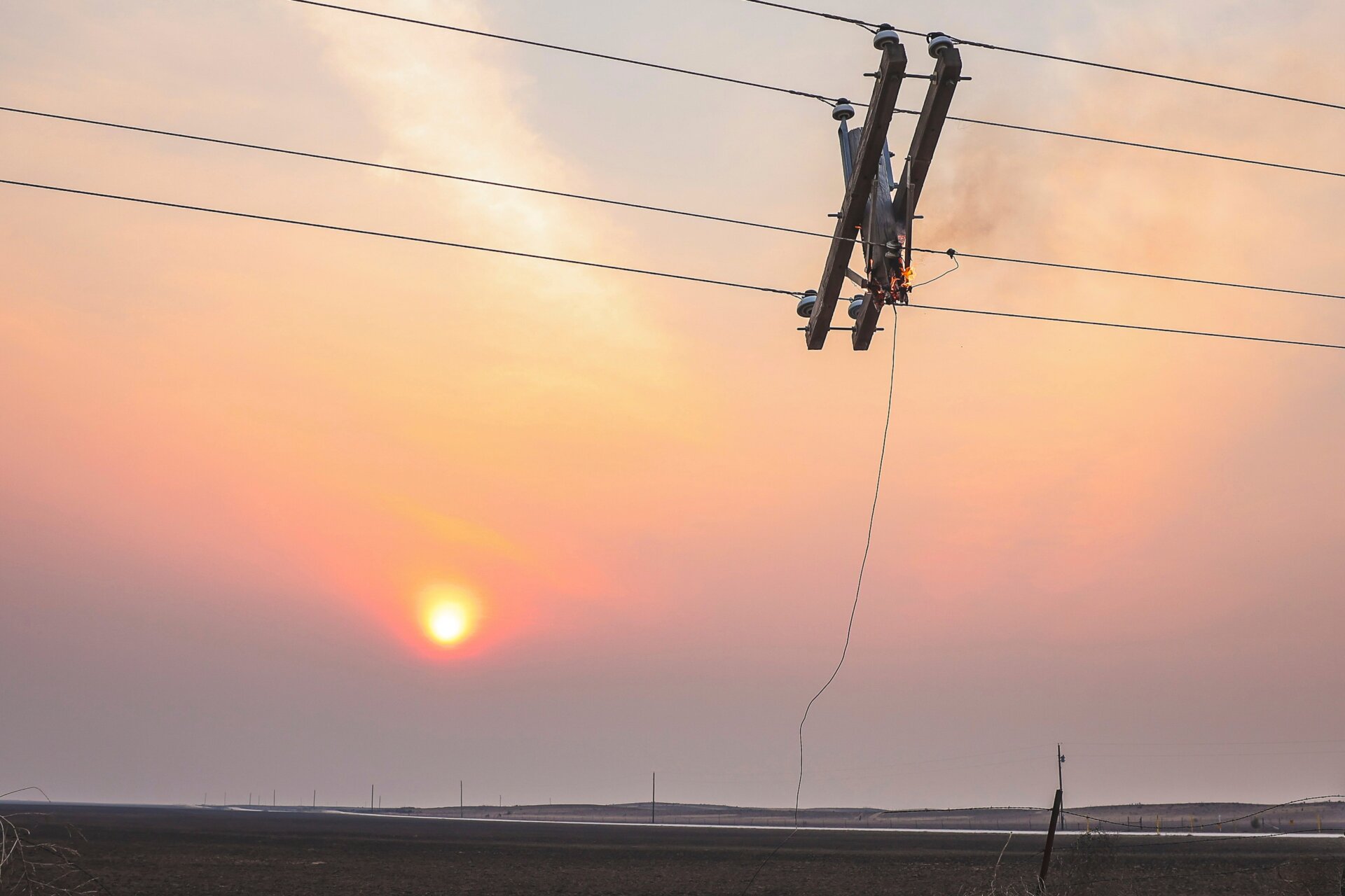 Ein Telefonmast brennt aus dem Smokehouse Creek Fire, als die Sonne untergeht, Mittwoch, 28. Februar 2024, in Kanada, Texas.