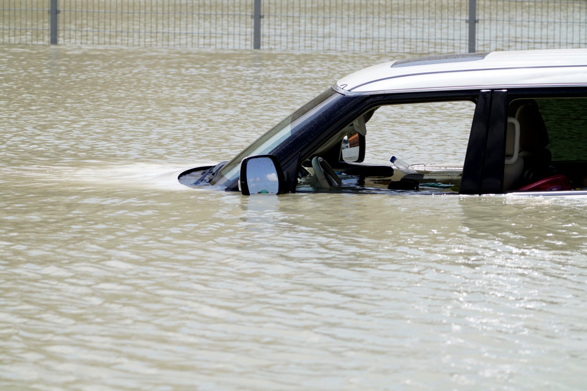 Trümmer treiben durch einen im Hochwasser zurückgelassenen SUV in Dubai, Vereinigte Arabische Emirate, Mittwoch, 17. April 2024. 
