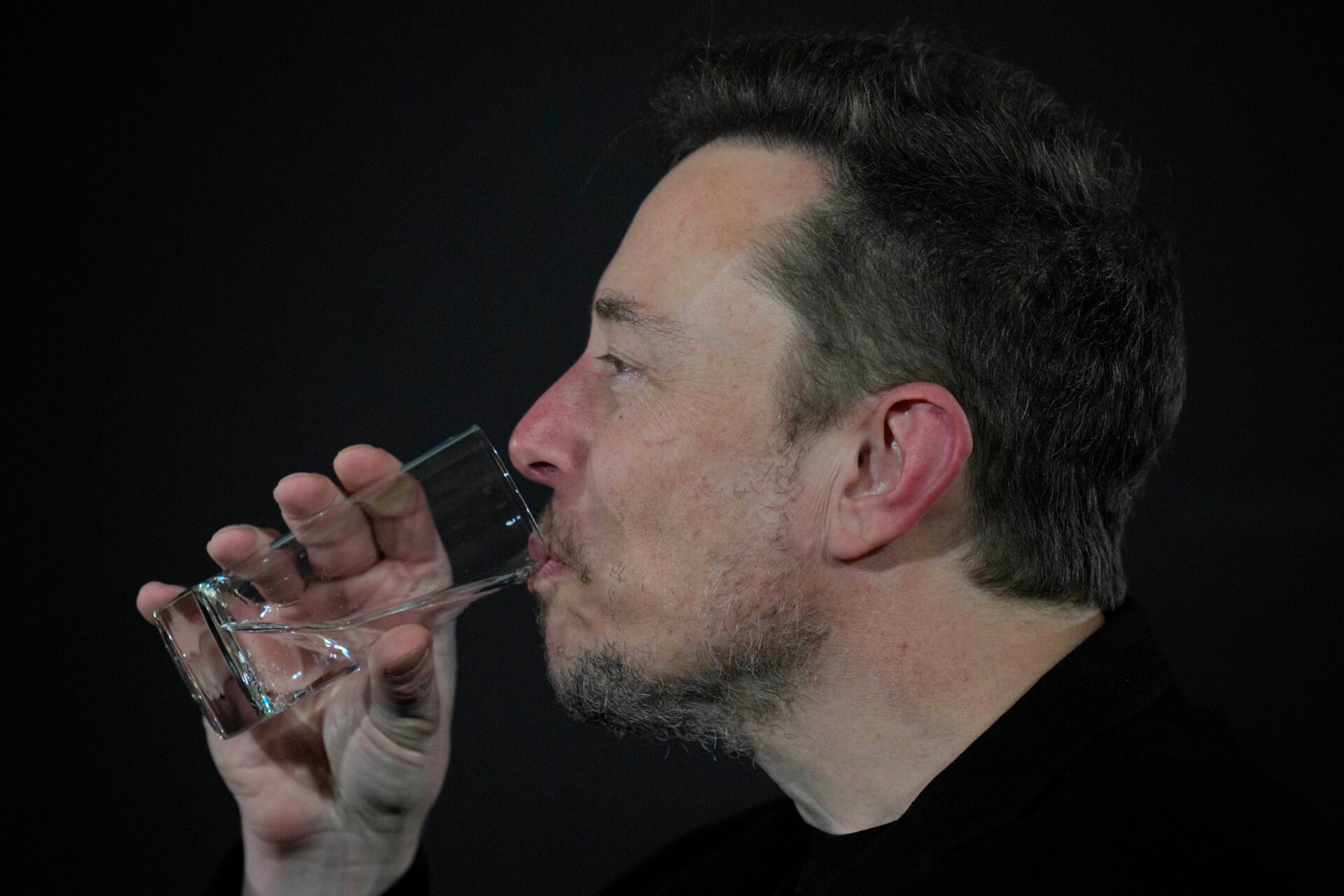 Elon Musk trinkt während einer Gesprächsveranstaltung mit dem britischen Premierminister Rishi Sunak in London, Donnerstag, 2. November 2023. 