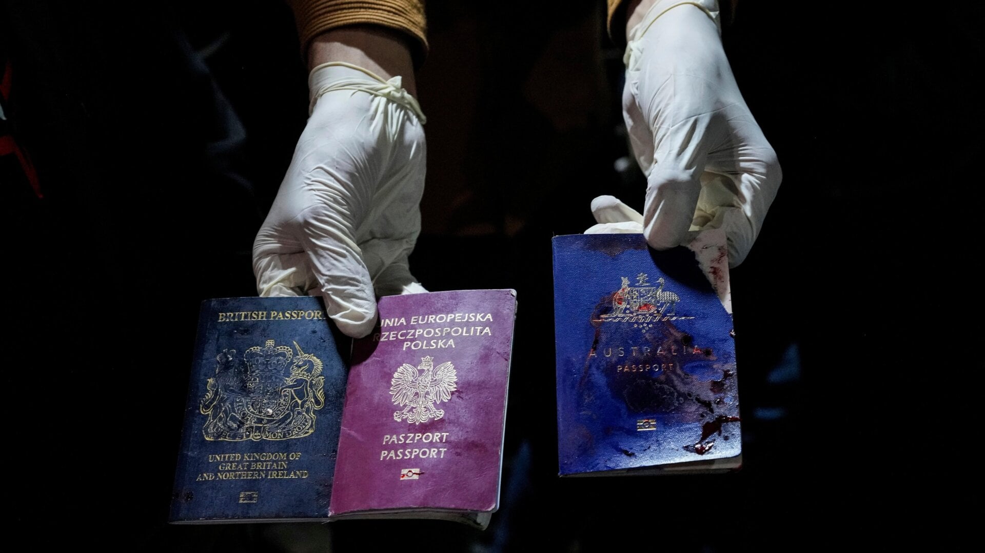 Ein Mann zeigt nach einem israelischen Luftangriff in Deir al-Balah, Gazastreifen, Montag, 1. April 2024, blutbefleckte britische, polnische und australische Pässe.