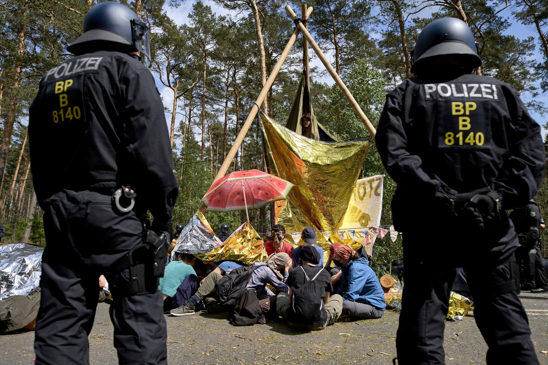 Polizisten stehen neben einer Straßenblockade durch Aktivisten während eines Protests gegen Tesla am 10. Mai 2024.  
