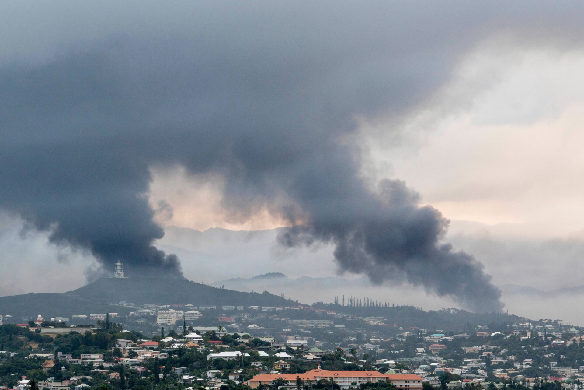 In der Ferne steigt am 14. Mai 2024 in Noumea, Neukaledonien, Rauch auf.