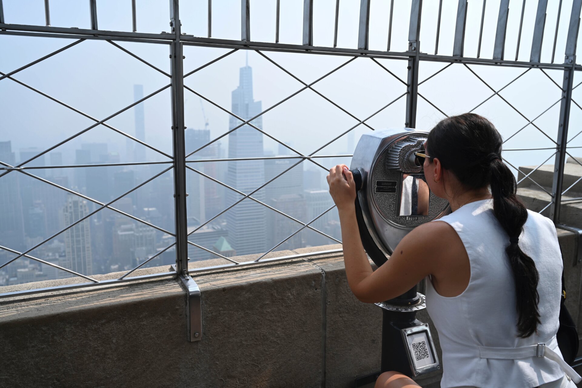 Menschen besuchen die Aussichtsplattform des Empire State Buildings, während der Rauch der kanadischen Waldbrände am 30. Juni 2023 die Skyline von Manhattan in New York City bedeckt.