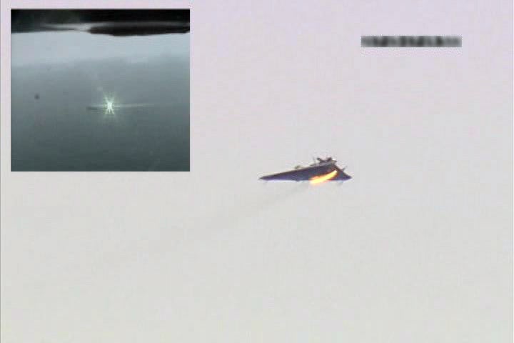 Ein Standbild aus einem Video zeigt eine geteilte Bildschirmansicht des Laserwaffensystems (LaWS) oben links, das 2012 ein ferngesteuertes Zielflugzeug trifft. 