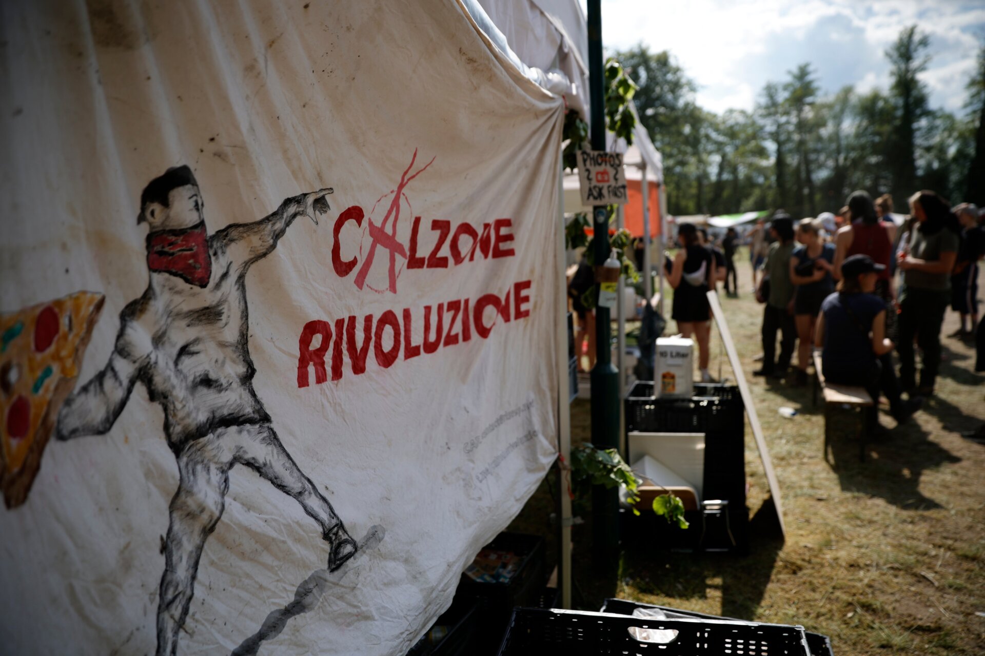 Am 10. Mai 2024 ist auf einem Zelt ein Bild eines militanten Aktivisten zu sehen, der eine Pizza mit der Aufschrift „Calzone Rivoluzione“ wirft. 