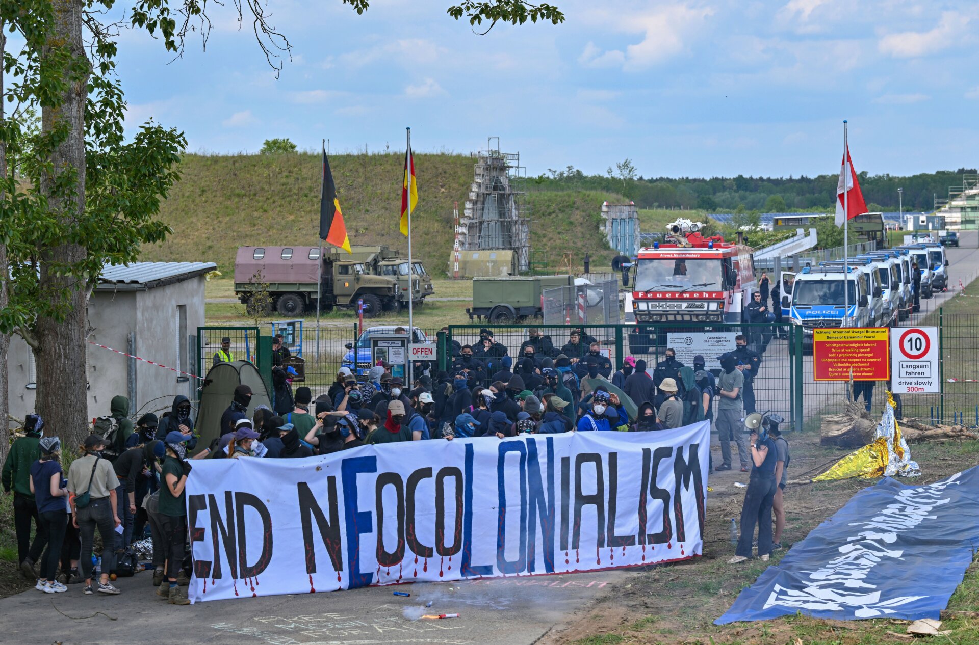Aktivisten blockieren am 10. Mai 2024 eine Zufahrtsstraße zum Flugplatz Neuhardenberg. 