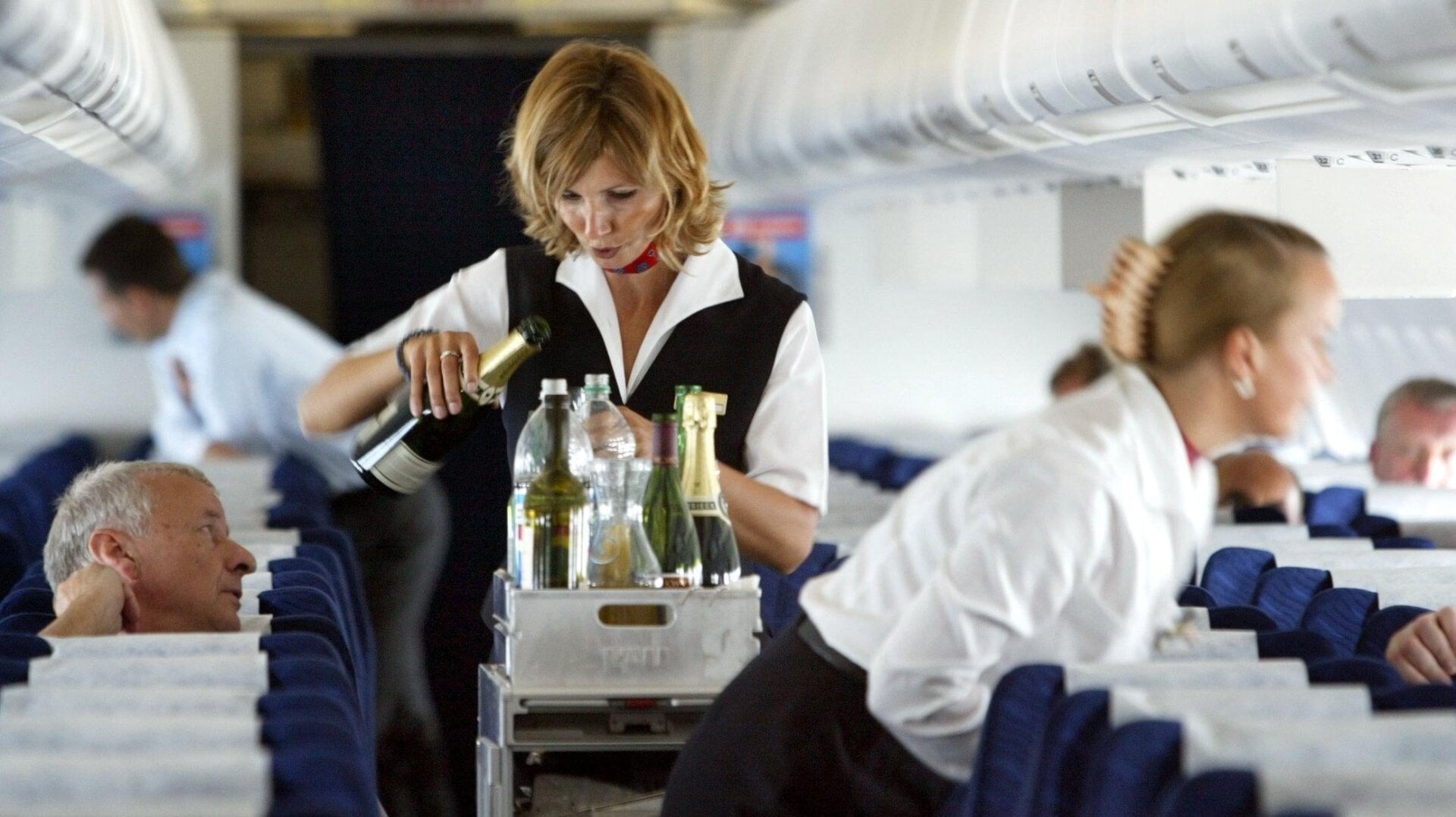 Eine Flugbegleiterin serviert Passagieren während eines Fluges von Dessau, Deutschland, am 17. Juli 2003 ein Getränk.