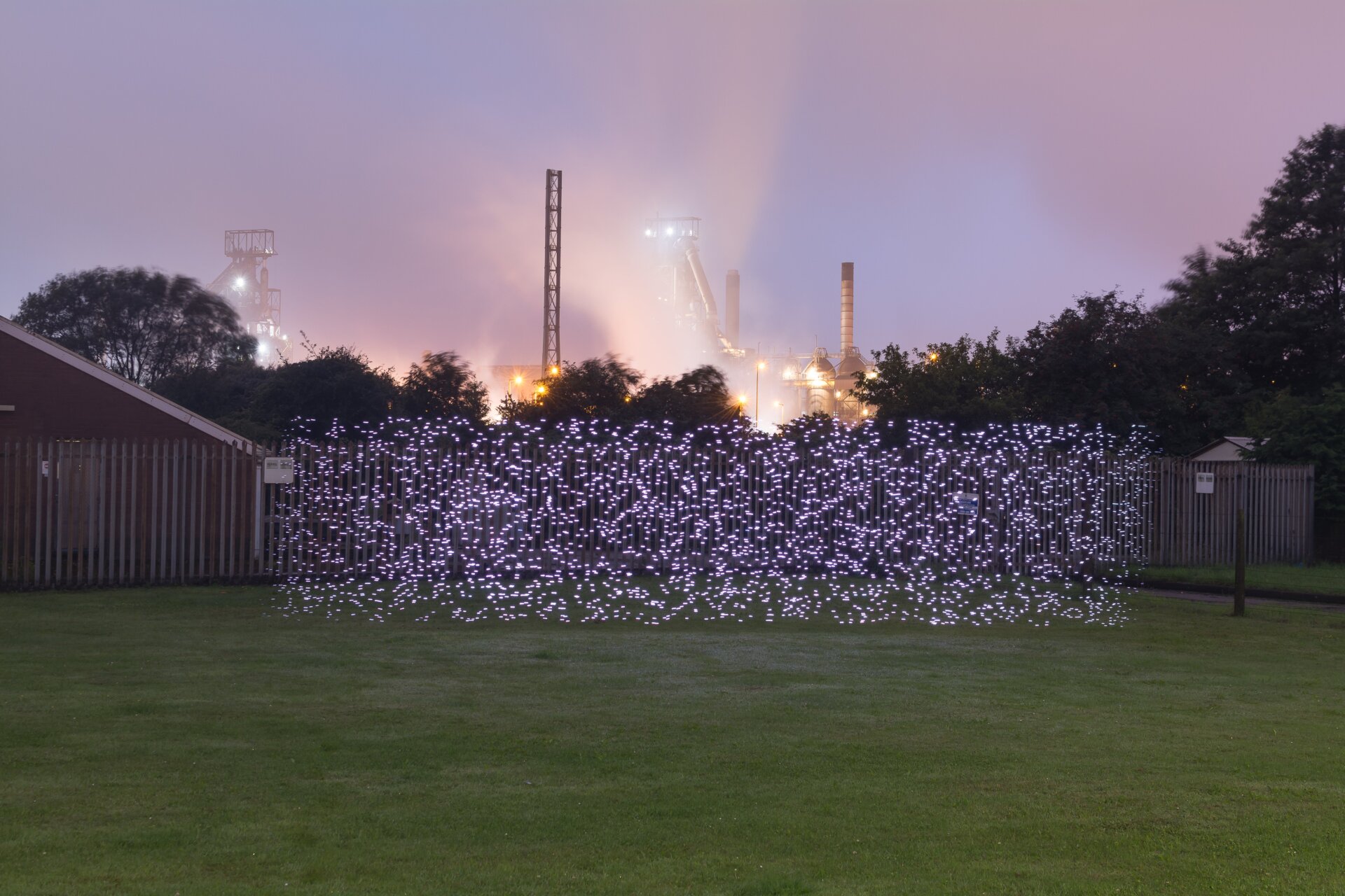 Ein Lichtgemälde in Port Talbot, Großbritannien, mit einer Stahlwerksfabrik im Hintergrund.