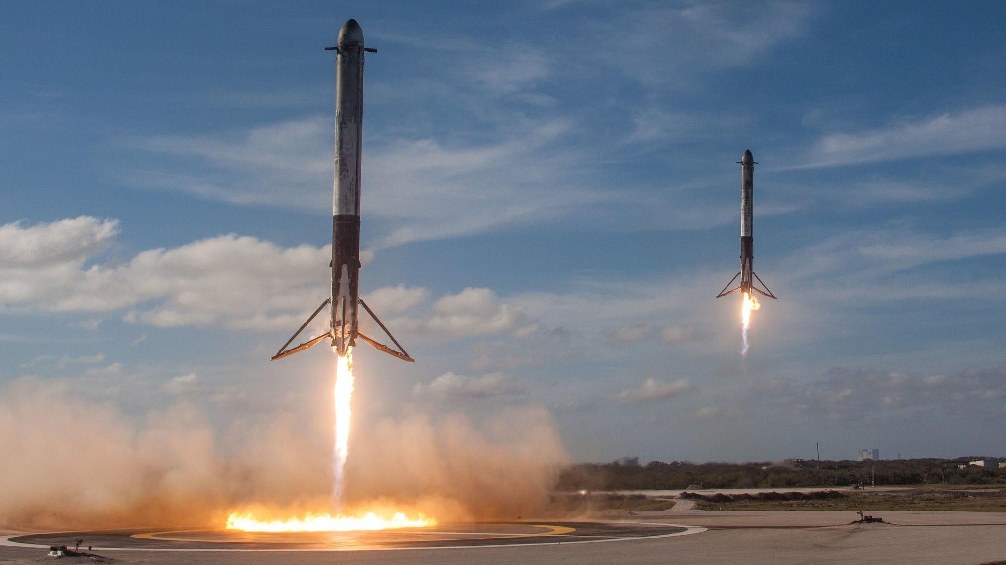 Ein Paar Falcon-Heavy-Side-Booster kehren während des Jungfernflugs der Rakete im Jahr 2018 zur Landung zurück.