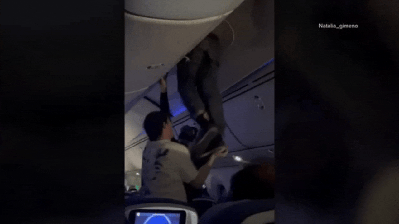 Videos, die am Montag viral gingen, zeigen, wie einem Mann beim Aussteigen geholfen wird, nachdem er während extremer Turbulenzen auf einem Flug von Spanien nach Uruguay in einer Gepäckablage feststeckte.
