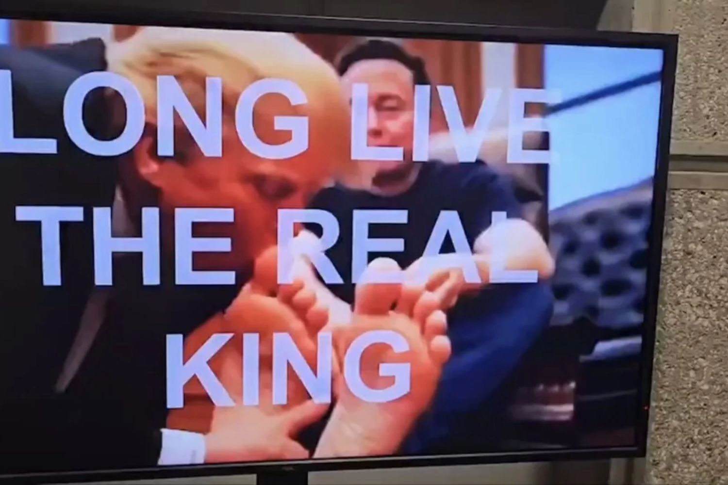 Bild des AI-generierten Videos, das Donald Trump zeigt, wie er die Füße von Elon Musk küsst, mit einem Text-Overlay, das „Lang lebe der wahre König“ liest.