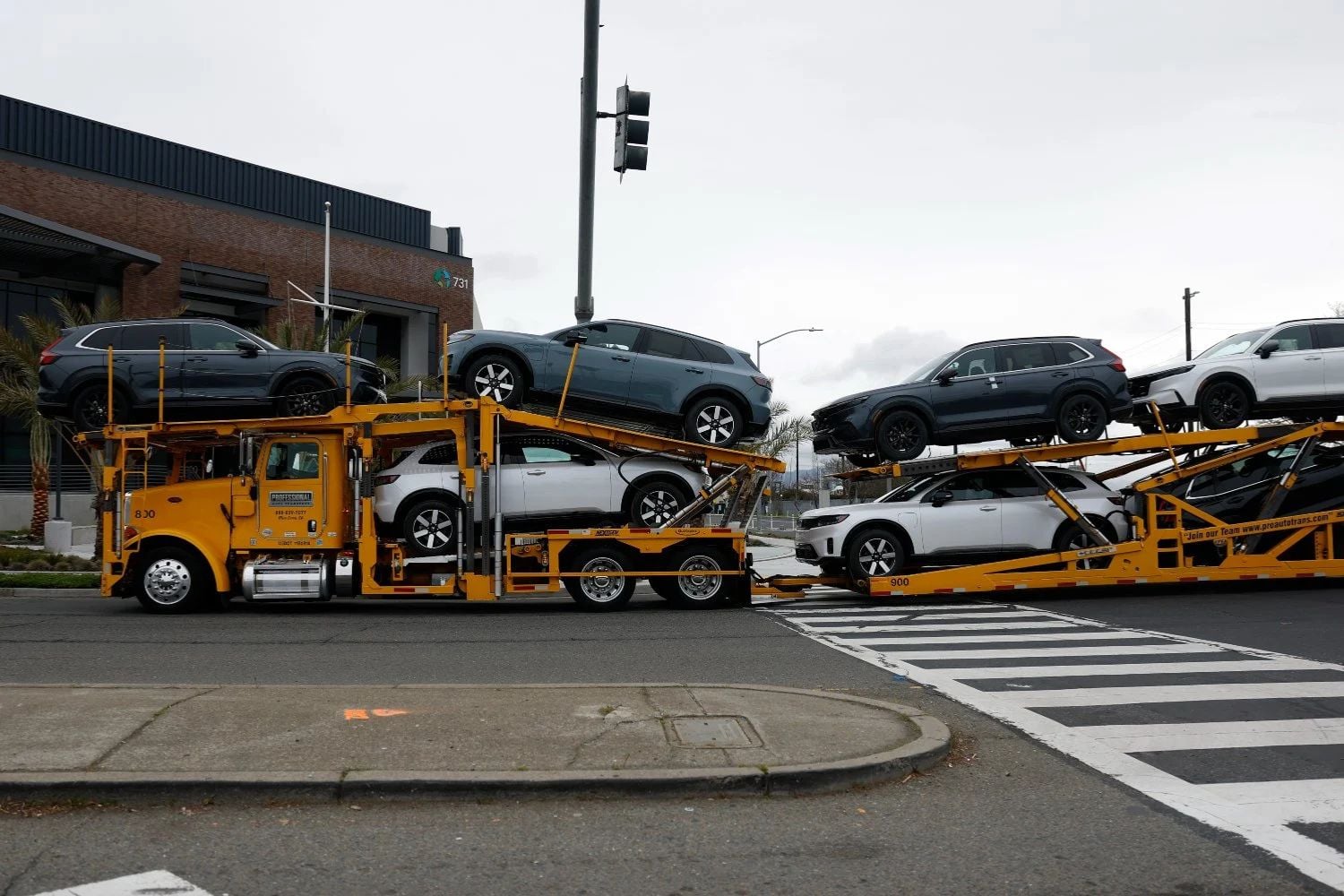 Ein Lkw mit einem Autotransportanhänger transportiert mehrere neue Fahrzeuge